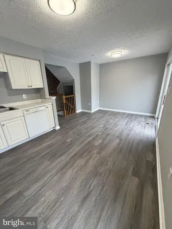 a view of a kitchen with wooden floor and electronic appliances