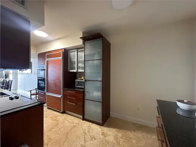 a kitchen with stainless steel appliances kitchen island granite countertop a refrigerator and a sink