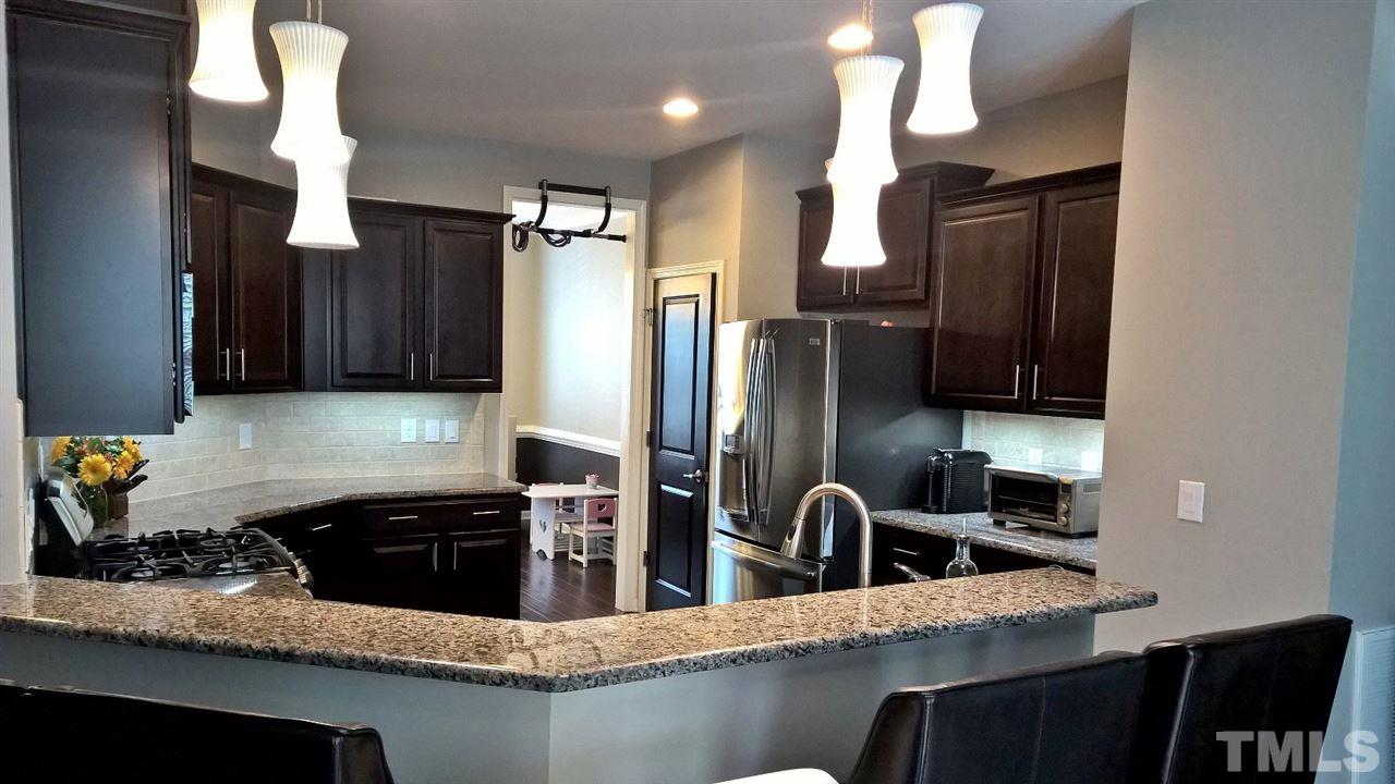 5619 Wade Park Boulevard Raleigh, NC 27607 - Photo 2 of 11 a kitchen with stainless steel appliances granite countertop a sink refrigerator and cabinets