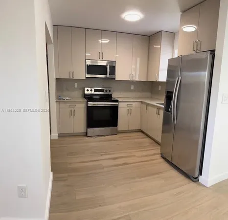 a kitchen with stainless steel appliances a refrigerator stove microwave and sink