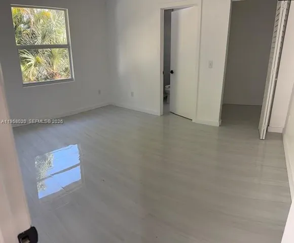 a view of a room with wooden floor and a sink
