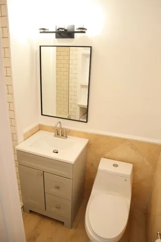 a bathroom with a toilet sink and mirror