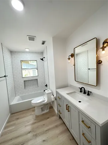 a bathroom with a double vanity sink toilet mirror and bathtub
