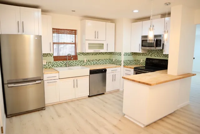 a kitchen with a stove a refrigerator and a sink