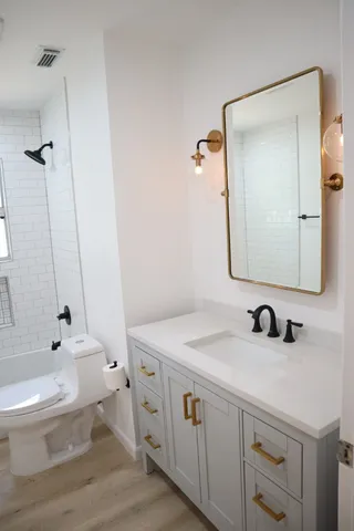 a bathroom with a sink a toilet and shower