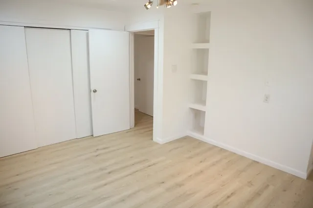 a view of an empty room with wooden floor