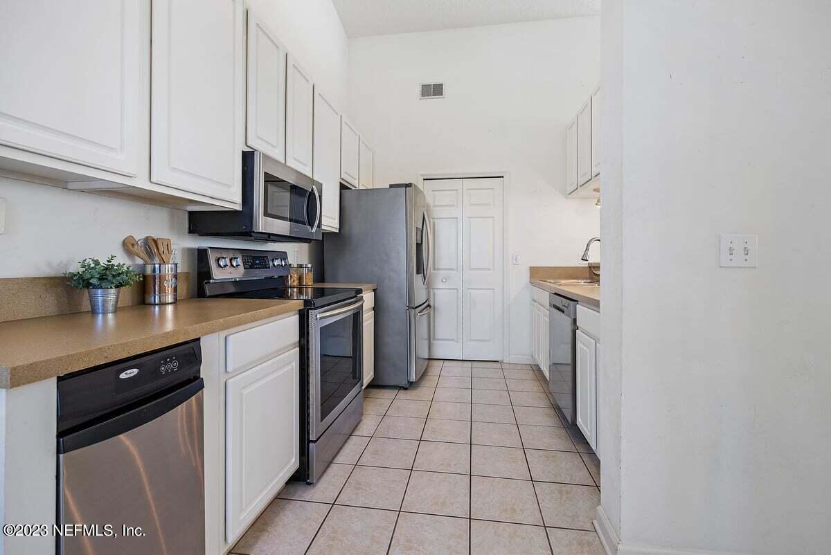811 Pine Valley Place St. Augustine, FL 32086 - Photo 6 of 30 a kitchen with stainless steel appliances a refrigerator sink and cabinets