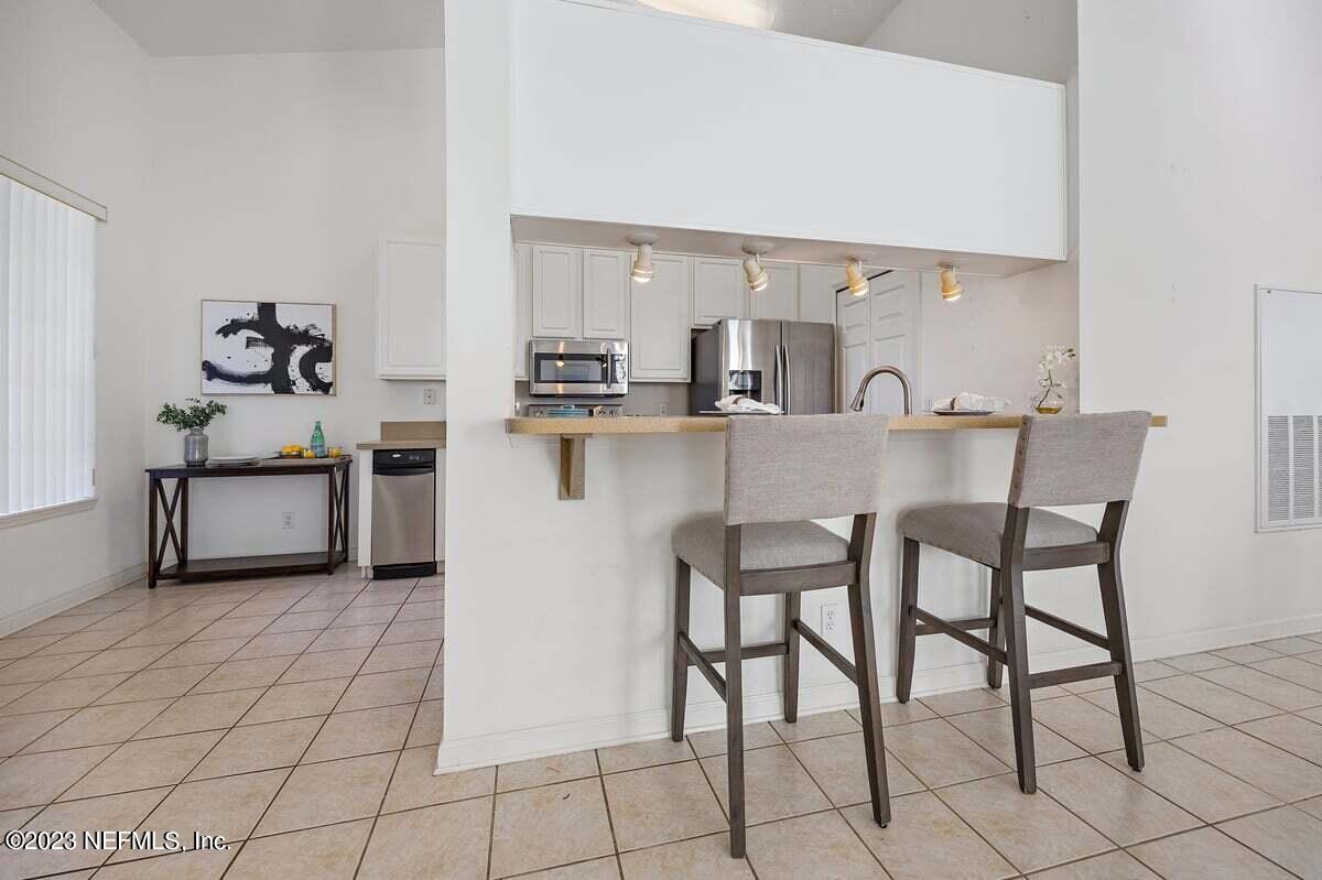 811 Pine Valley Place St. Augustine, FL 32086 - Photo 8 of 30 a kitchen with stainless steel appliances a table and chairs in it