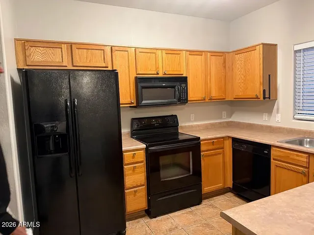 a kitchen with granite countertop a refrigerator stove and microwave