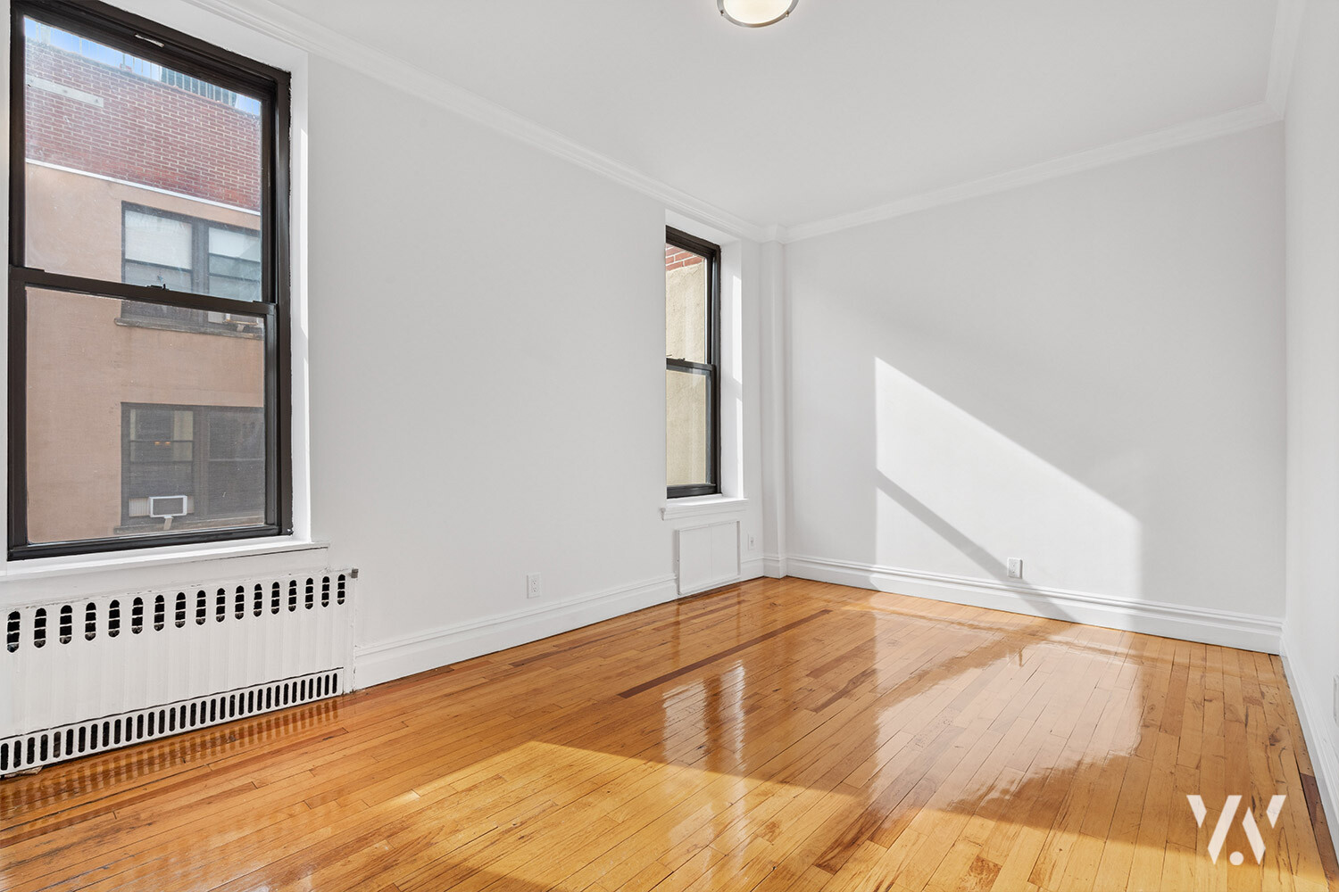 112 West 72nd Street, Unit 12E Manhattan, NY 10023 - Photo 7 of 11 a view of an empty room with wooden floor and a window