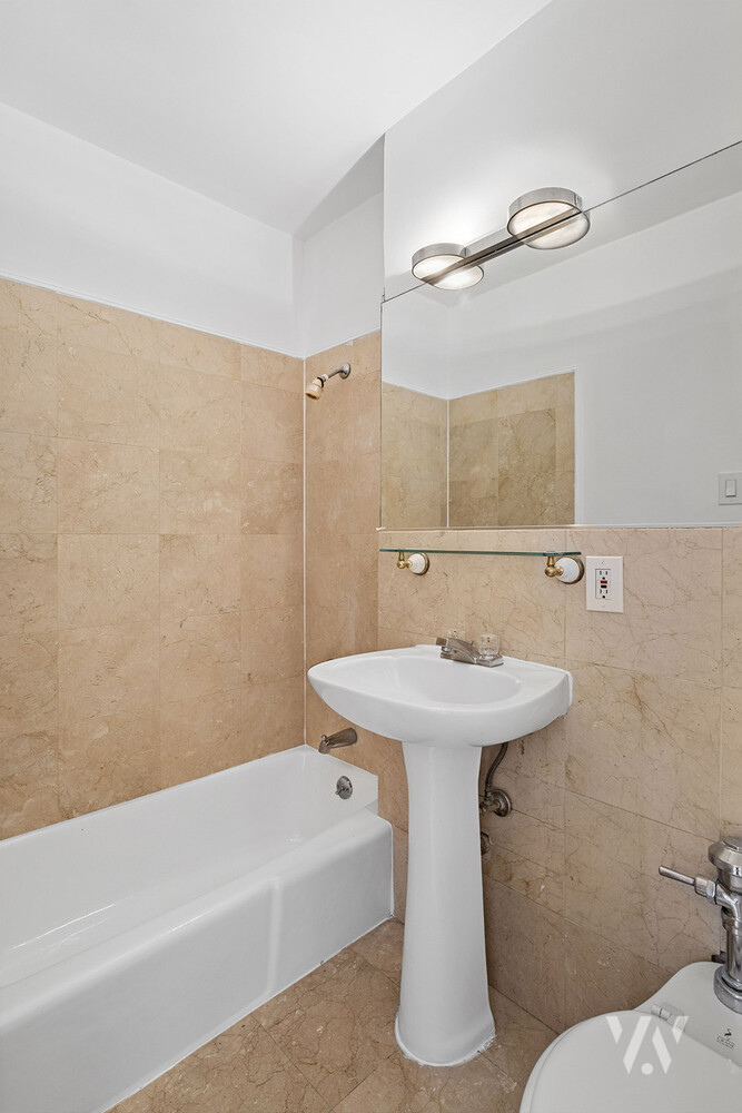 112 West 72nd Street, Unit 12E Manhattan, NY 10023 - Photo 8 of 11 a bathroom with a sink a toilet and shower