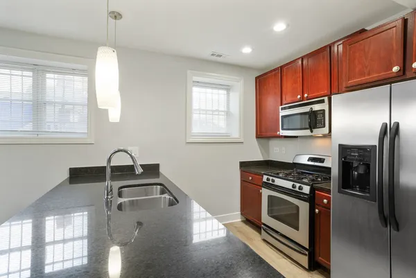 a kitchen that has a sink cabinets stainless steel appliances and window