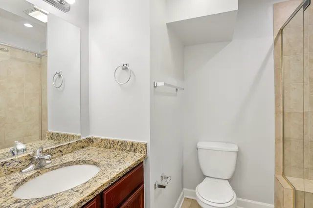 a bathroom with a granite countertop sink toilet and shower