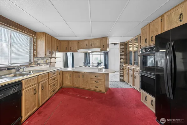 a large kitchen with cabinets stainless steel appliances and window