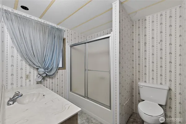 a bathroom with a sink a toilet and shower