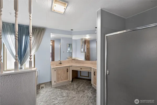 a bathroom with a granite countertop sink a mirror and a shower