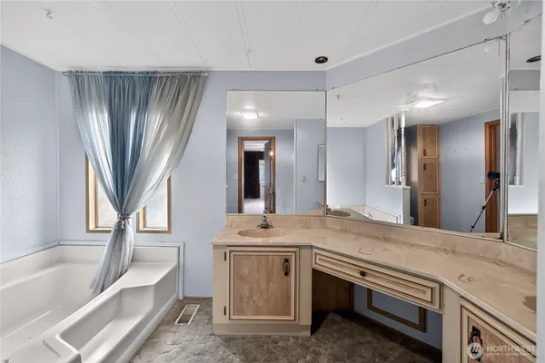 a bathroom with a granite countertop sink a toilet a vanity and bathtub