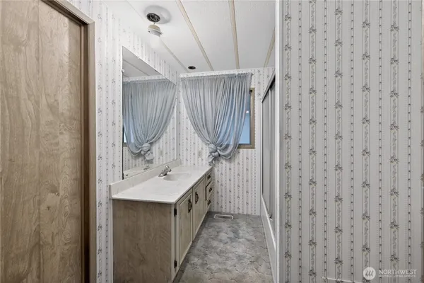 a bathroom with a sink a mirror and a shower curtain