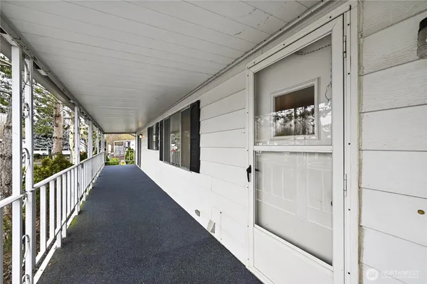 a view of a porch with wooden floor and front door