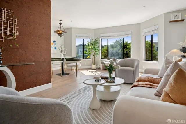 a living room with furniture fireplace and large windows