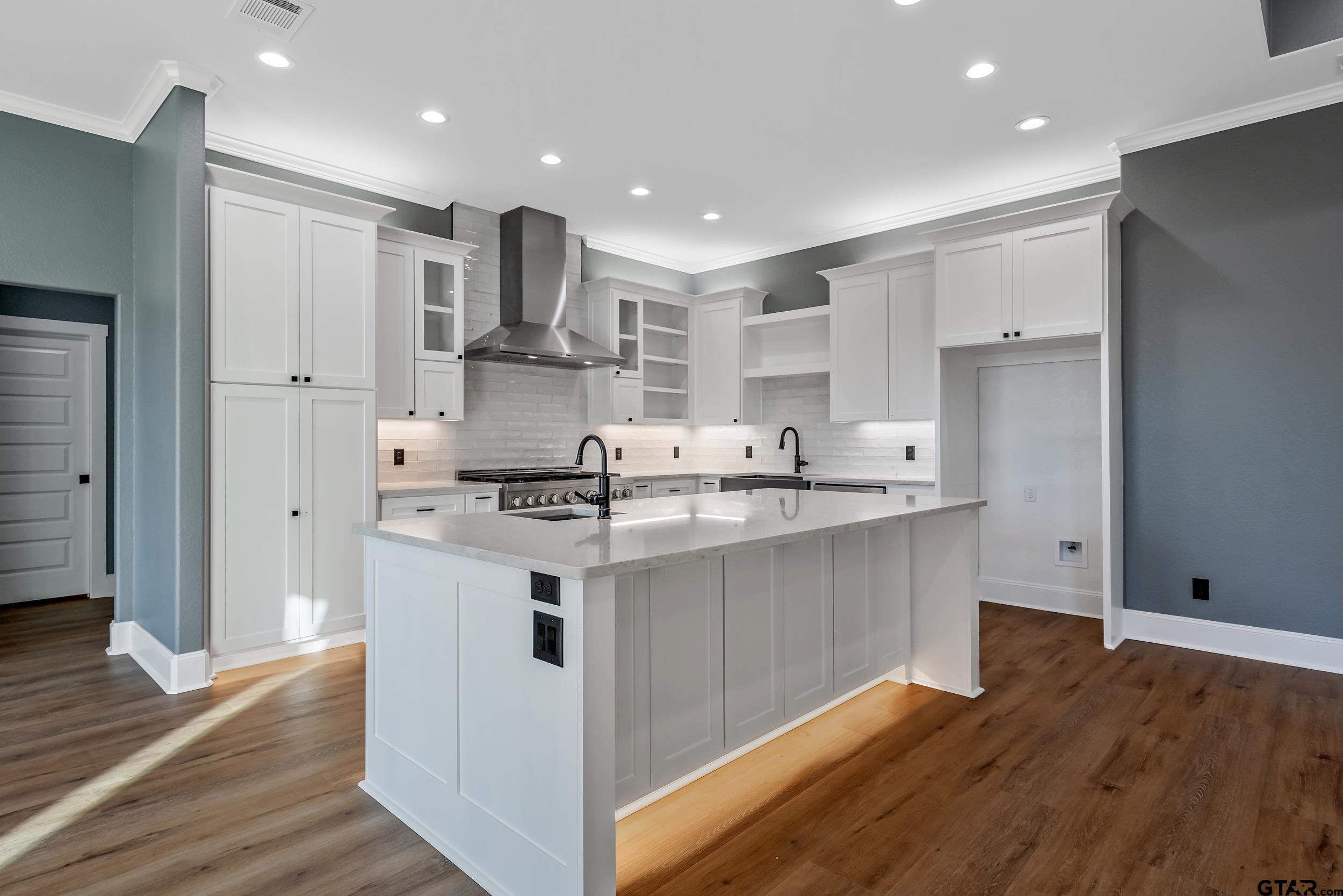 12241 Madison Crossing Bullard, TX 75757 - Photo 21 of 38 a kitchen with stainless steel appliances granite countertop a refrigerator a sink dishwasher a stove and white cabinets with wooden floor