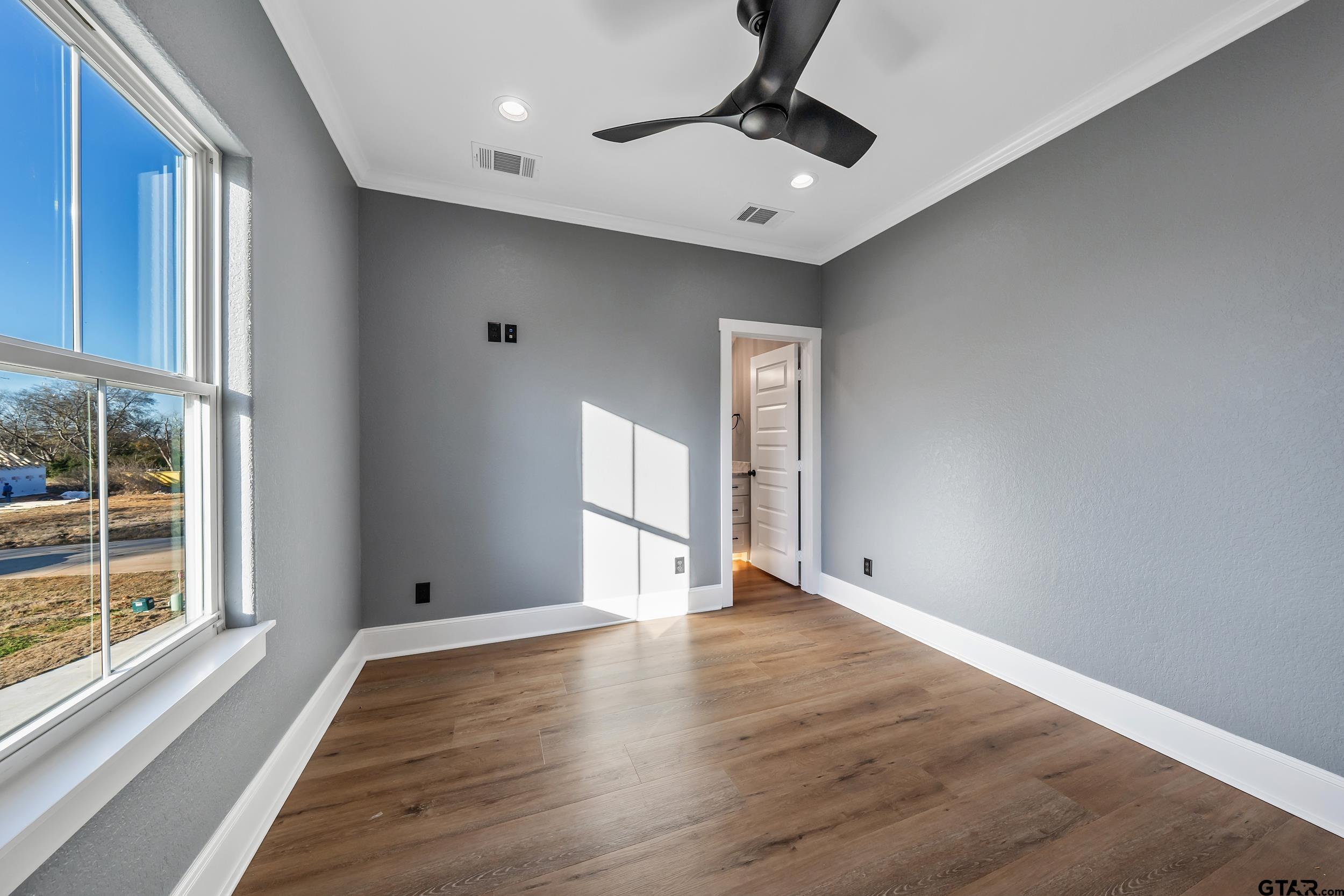 12241 Madison Crossing Bullard, TX 75757 - Photo 10 of 38 a view of an empty room with wooden floor and a window