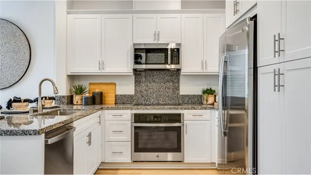 a kitchen with stainless steel appliances granite countertop a stove and a refrigerator