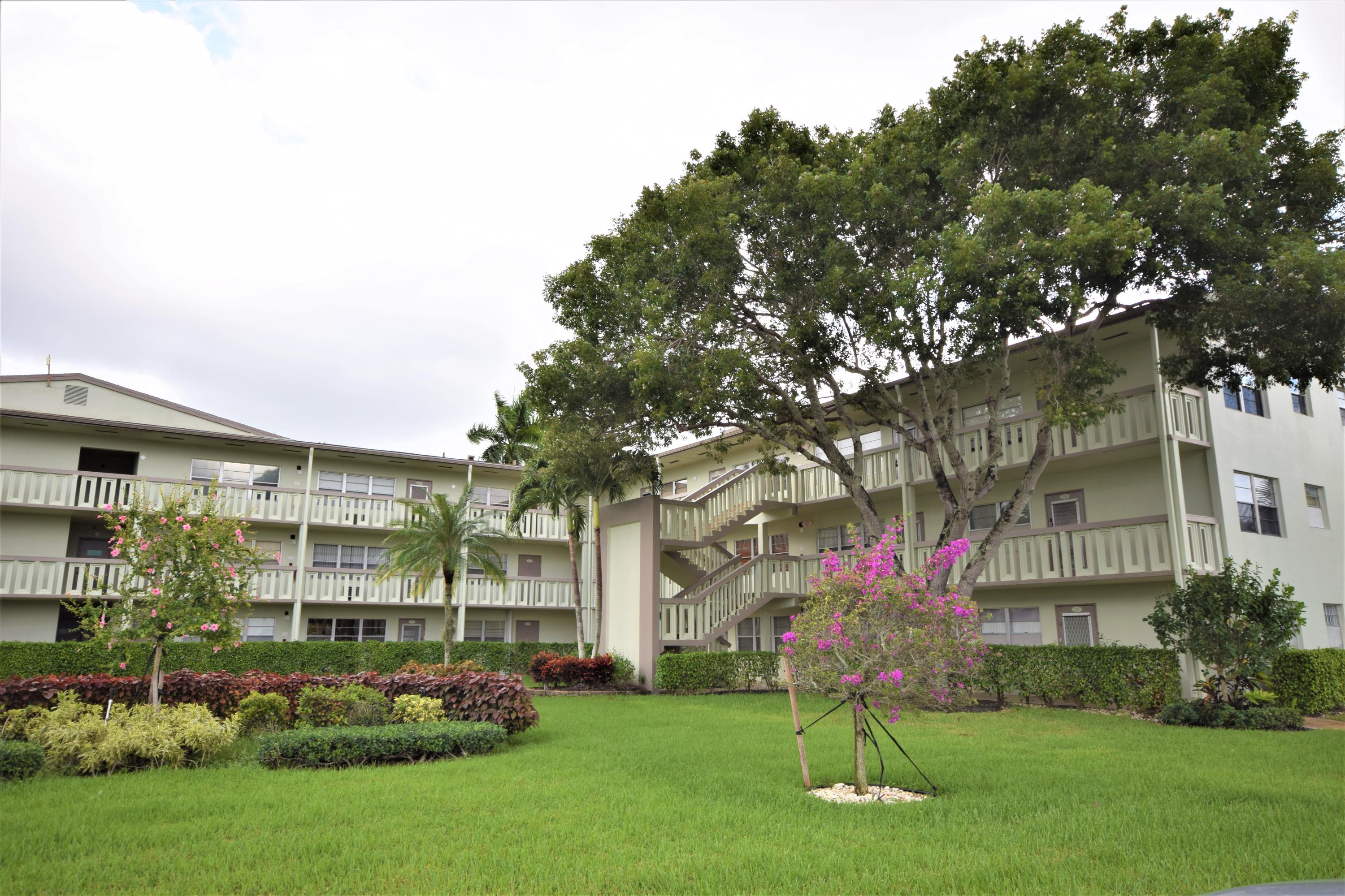 29 Dorset A Boca Raton, FL 33434 - Photo 19 of 22 a front view of a building with a garden and plants