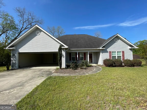 a front view of a house with yard and green space
