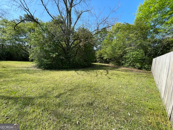 a house that has a big yard with wooden fence