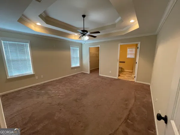 en empty room with windows and ceiling fan