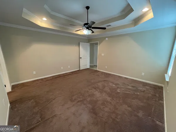 a view of an empty room with a ceiling fan