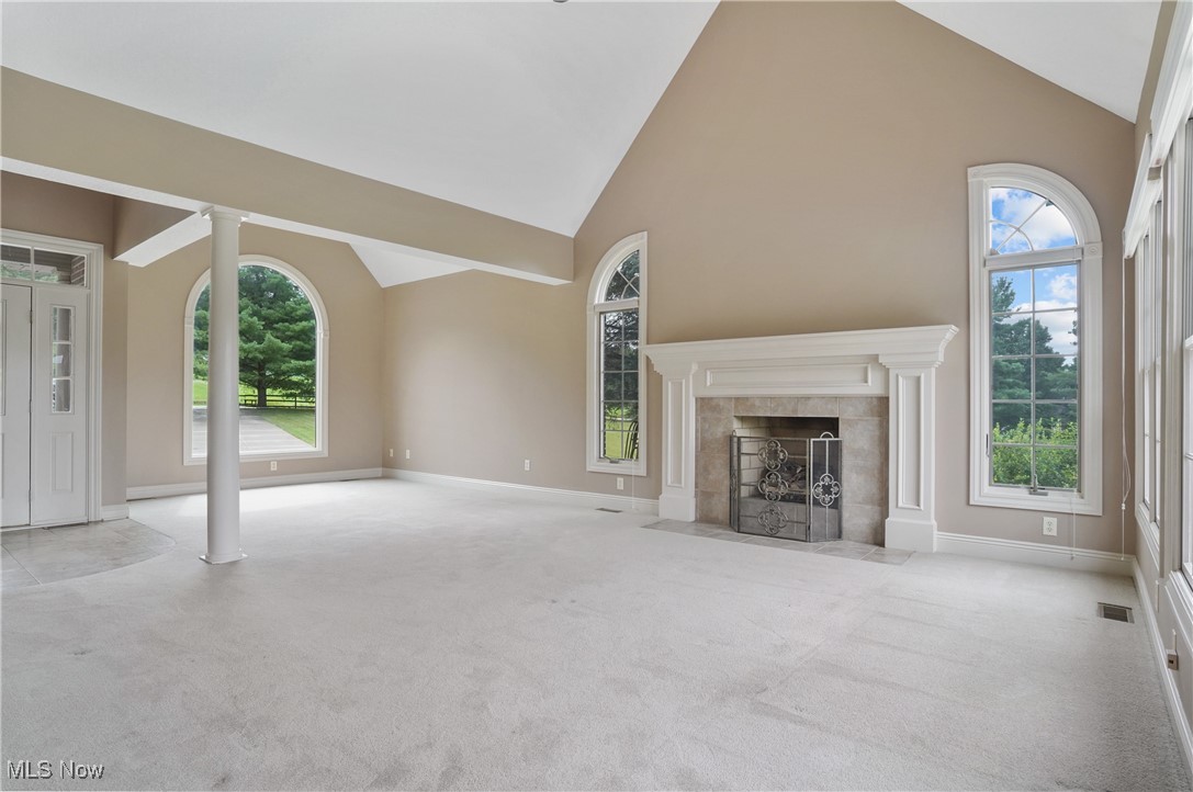 5952 Beach Road Wadsworth, OH 44281 - Photo 5 of 40 living room featuring high vaulted ceiling, carpet, a tiled fireplace, and decorative columns