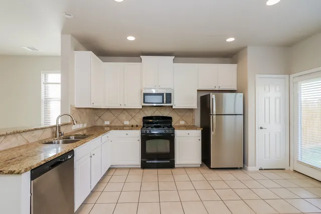 a kitchen with a sink a refrigerator and cabinets
