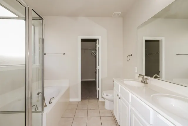 a bathroom with a bathtub sink mirror and toilet