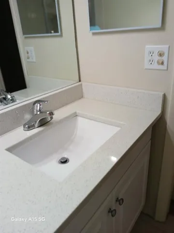 a bathroom with a sink a toilet and a mirror