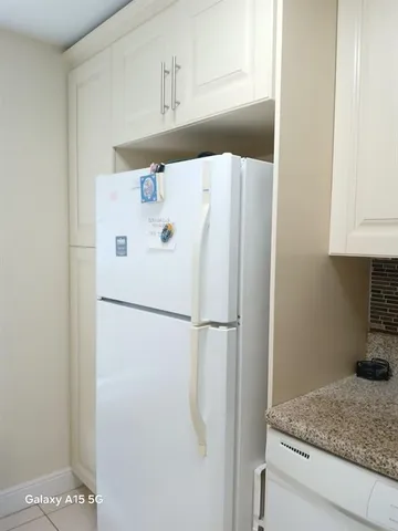 a kitchen with white cabinets and sink