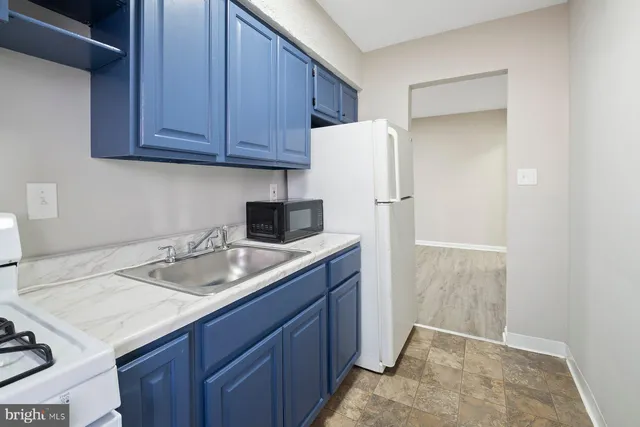 a kitchen with a sink a refrigerator and cabinets