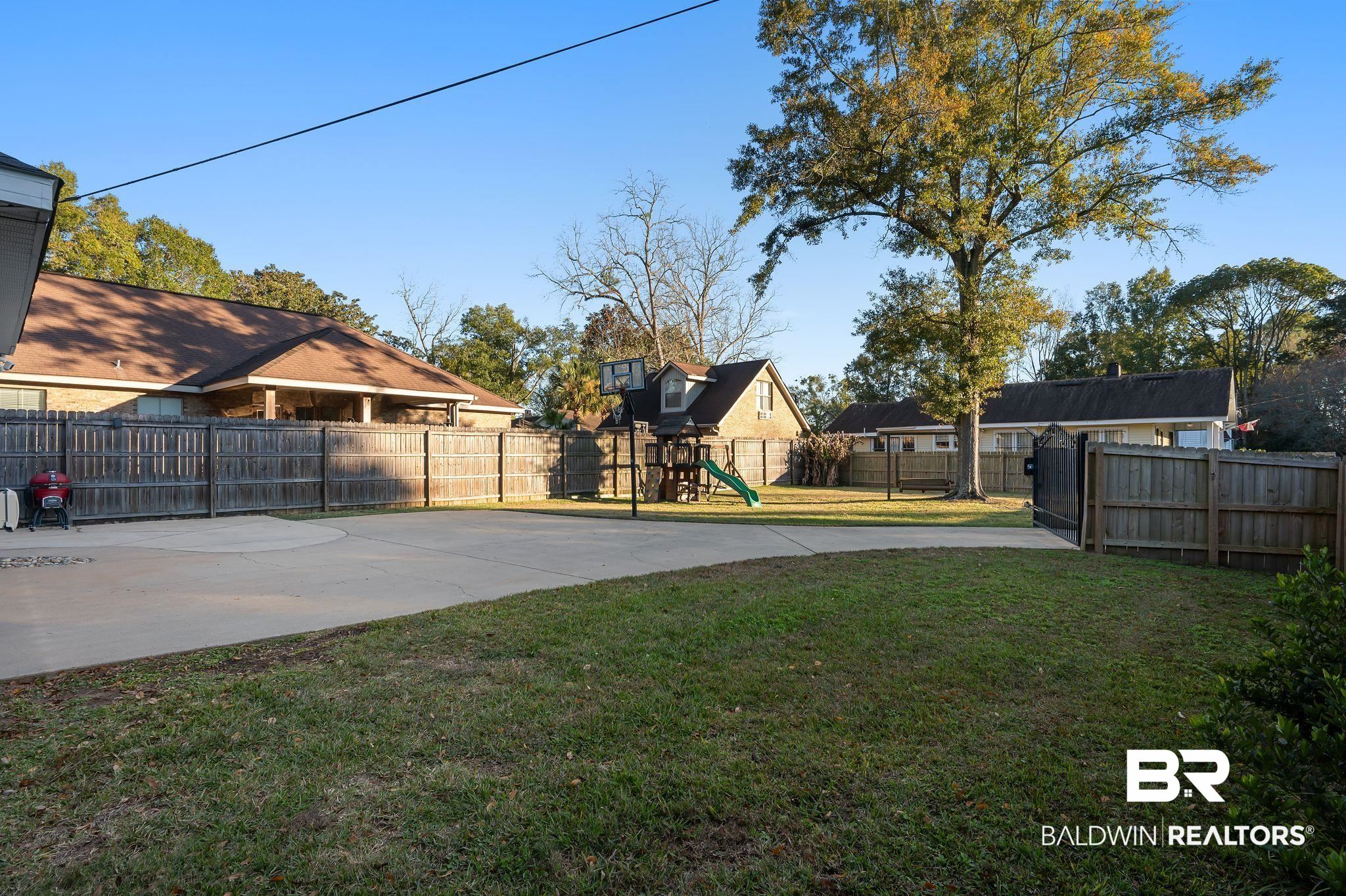 1825 Spring Hill Avenue Mobile, AL 36607 - Photo 36 of 43 Fenced backyard featuring a playground and concrete driveway