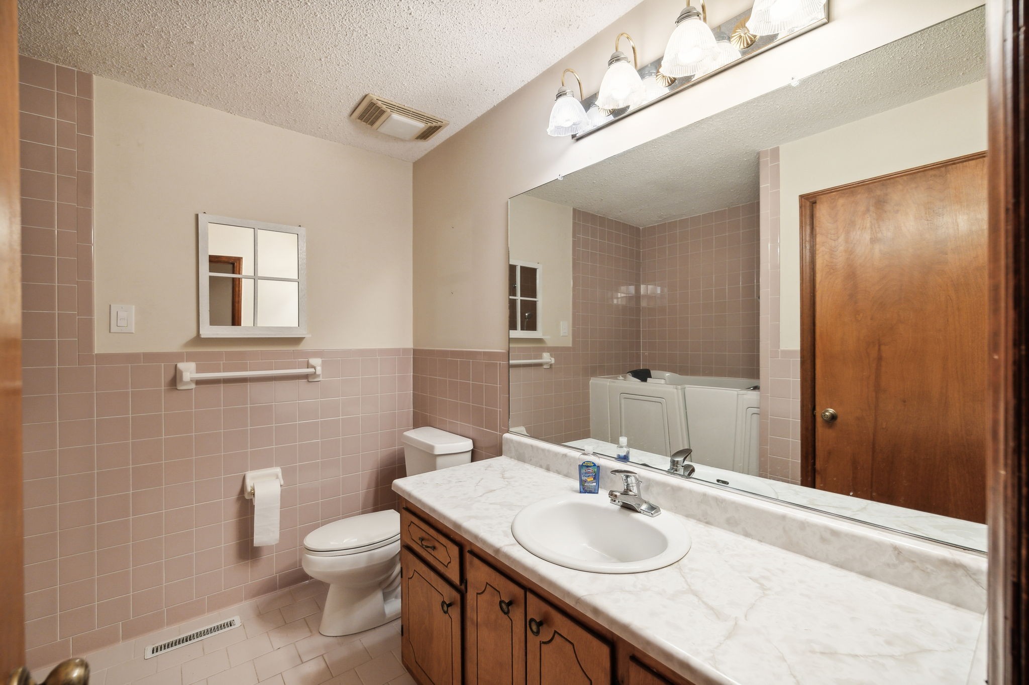 4068 Confederate Road Murfreesboro, TN 37128 - Photo 27 of 53 This is the Hall Bath with vanity and single sink. You can see the walk-in tub in the mirror that was installed in place of a regular tub.