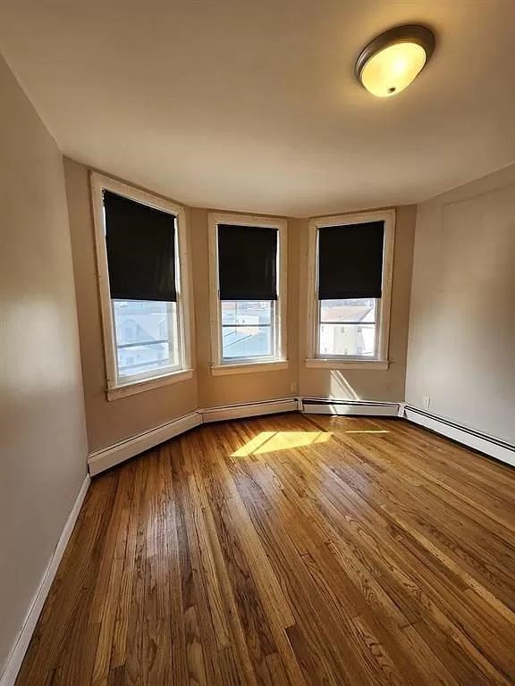 14 Cooper Street, Unit 2F Bayonne, NJ 07002 - Photo 5 of 6 a view of an empty room with wooden floor and a window