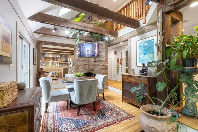 a view of a dining room with furniture a rug and wooden floor