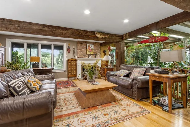 a living room with fireplace furniture and a large window