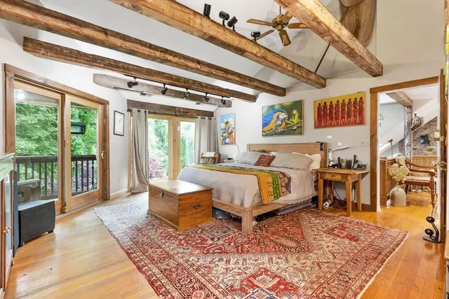 a bedroom with a bed a couch and large window with balcony view