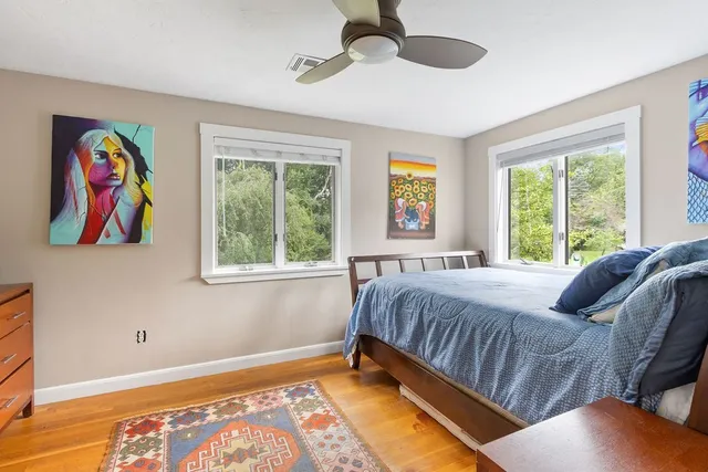 a bedroom with a bed and a painting on the wall