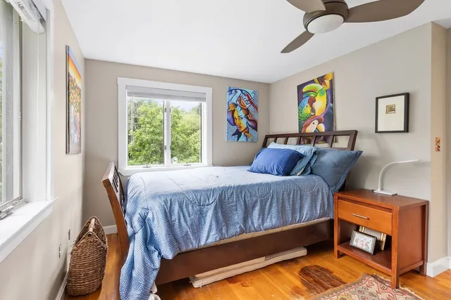 a bedroom with a bed and wooden floor