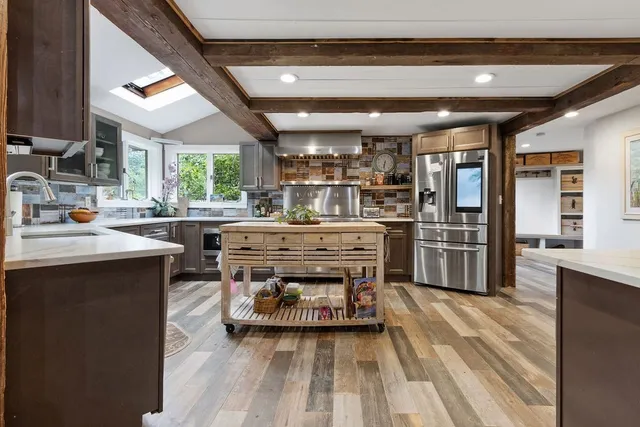 a kitchen with stainless steel appliances a stove a sink and a refrigerator