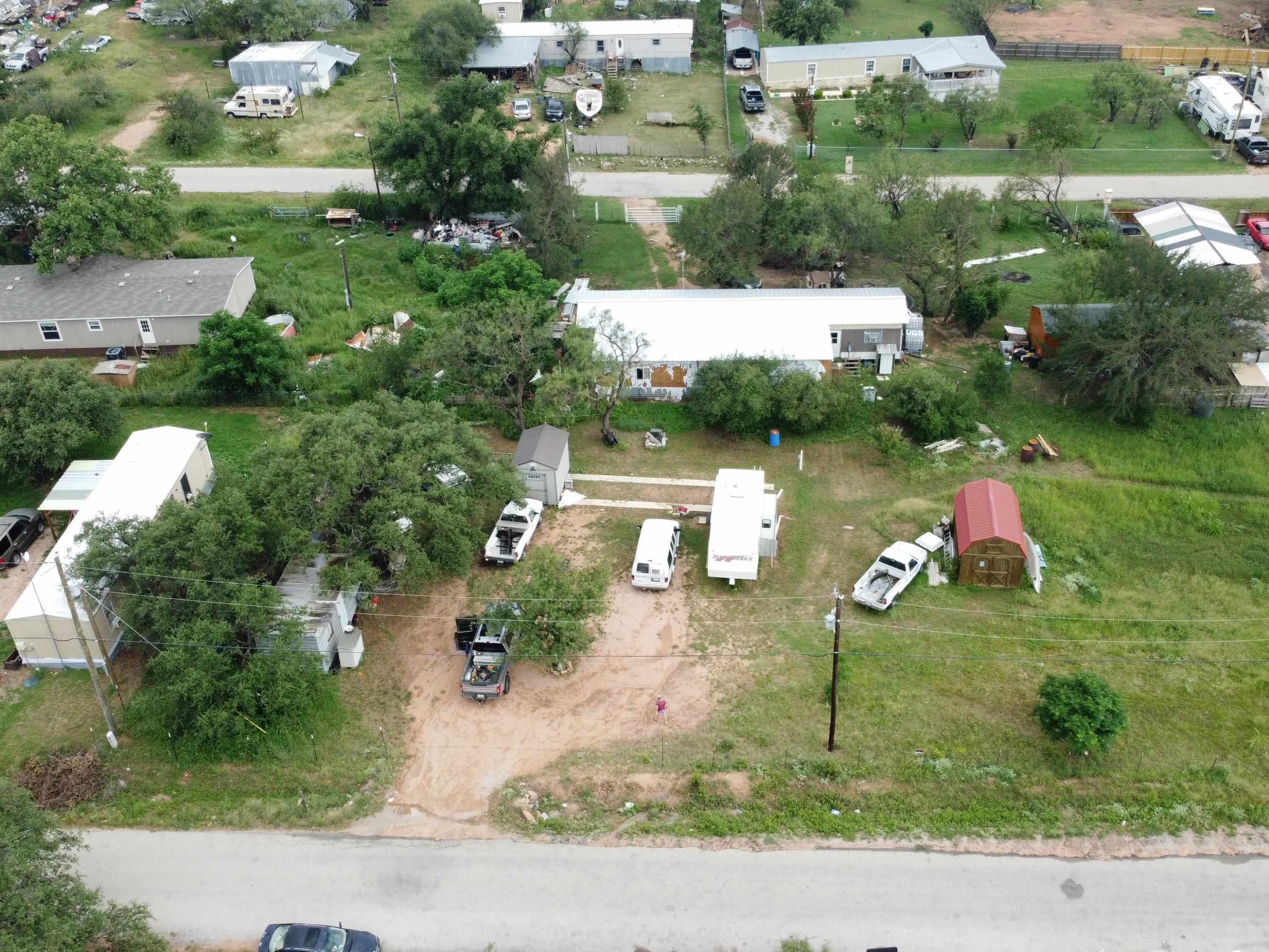 an aerial view of a house with a yard and lake