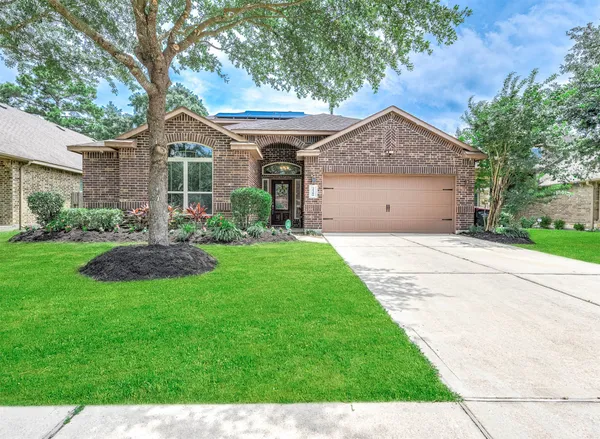 a front view of a house with yard and green space