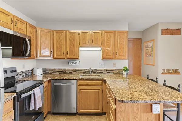 a kitchen with granite countertop a sink stove and cabinets
